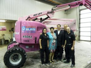 JLG dealer Location Blais painted a JLG 450AJ articulating boom lift pink to raise breast cancer awareness. Standing beside the lift are, from left to right, Christina Bolduc, Denise Racette, breast cancer patient and mother of Serge Blais, Serge Blais, Jr., Location Blais owner, Marc Blais, Location Blais president and general manager, and Olivier Gauthier, development officer with the Canadian Cancer Society's Quebec Division.