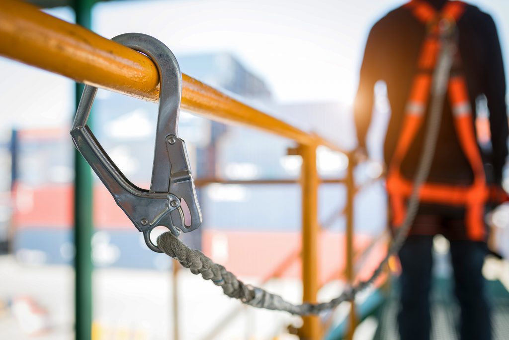 A man on a bridge holding scissors.