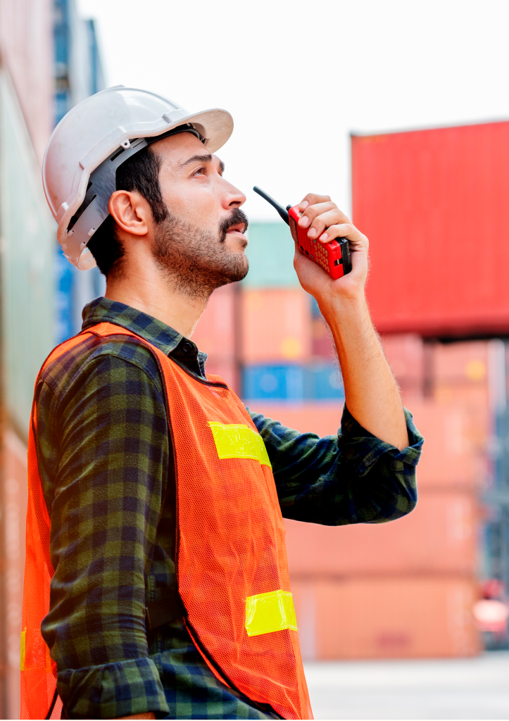 A man in a safety vest discussing pricing on his cell phone.